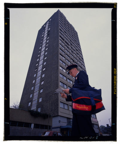 Postman Jamie Long sorts out his delivery to flats in Battersea, London, c.1988-1989